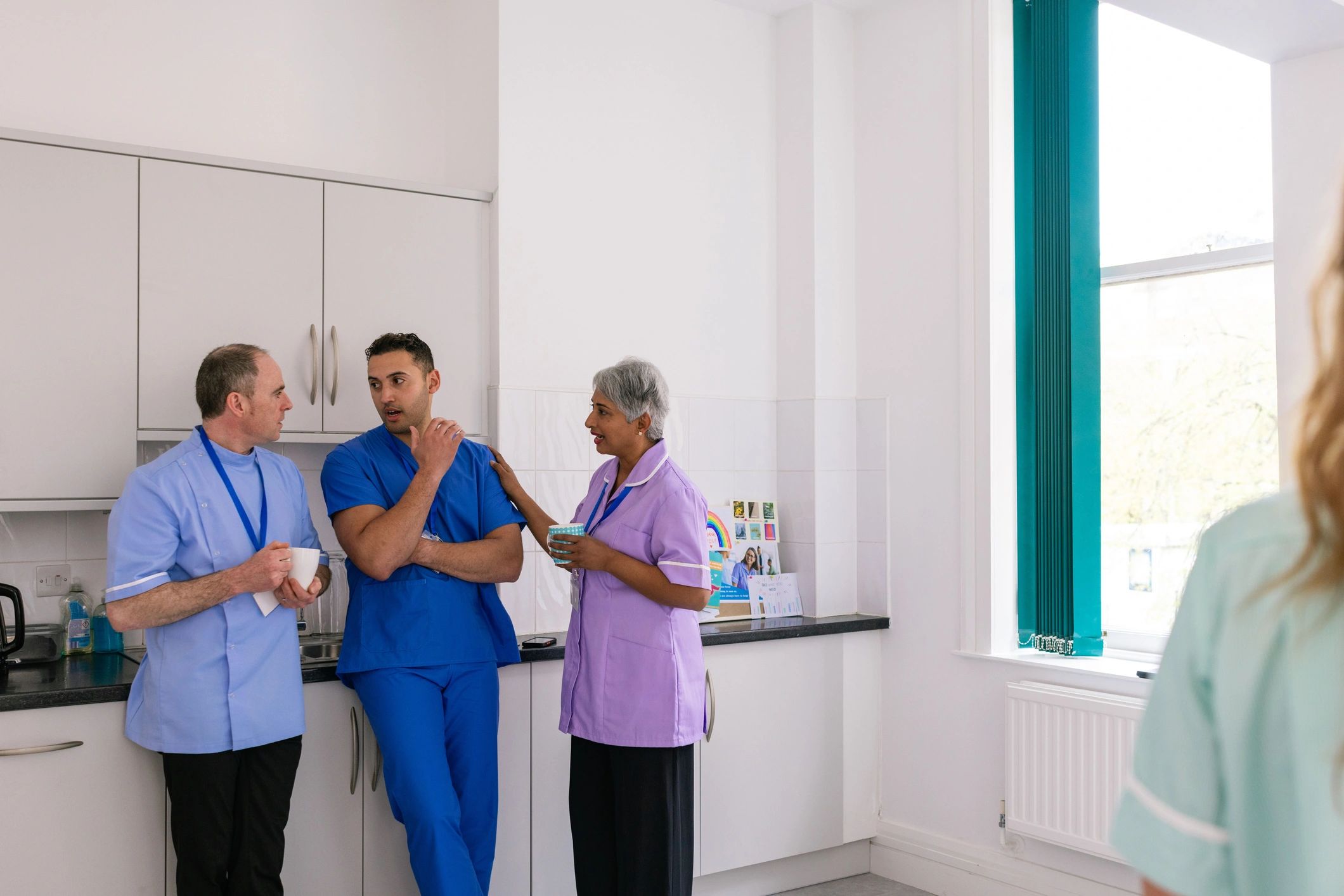 Healthcare professionals supporting one another in a staffroom