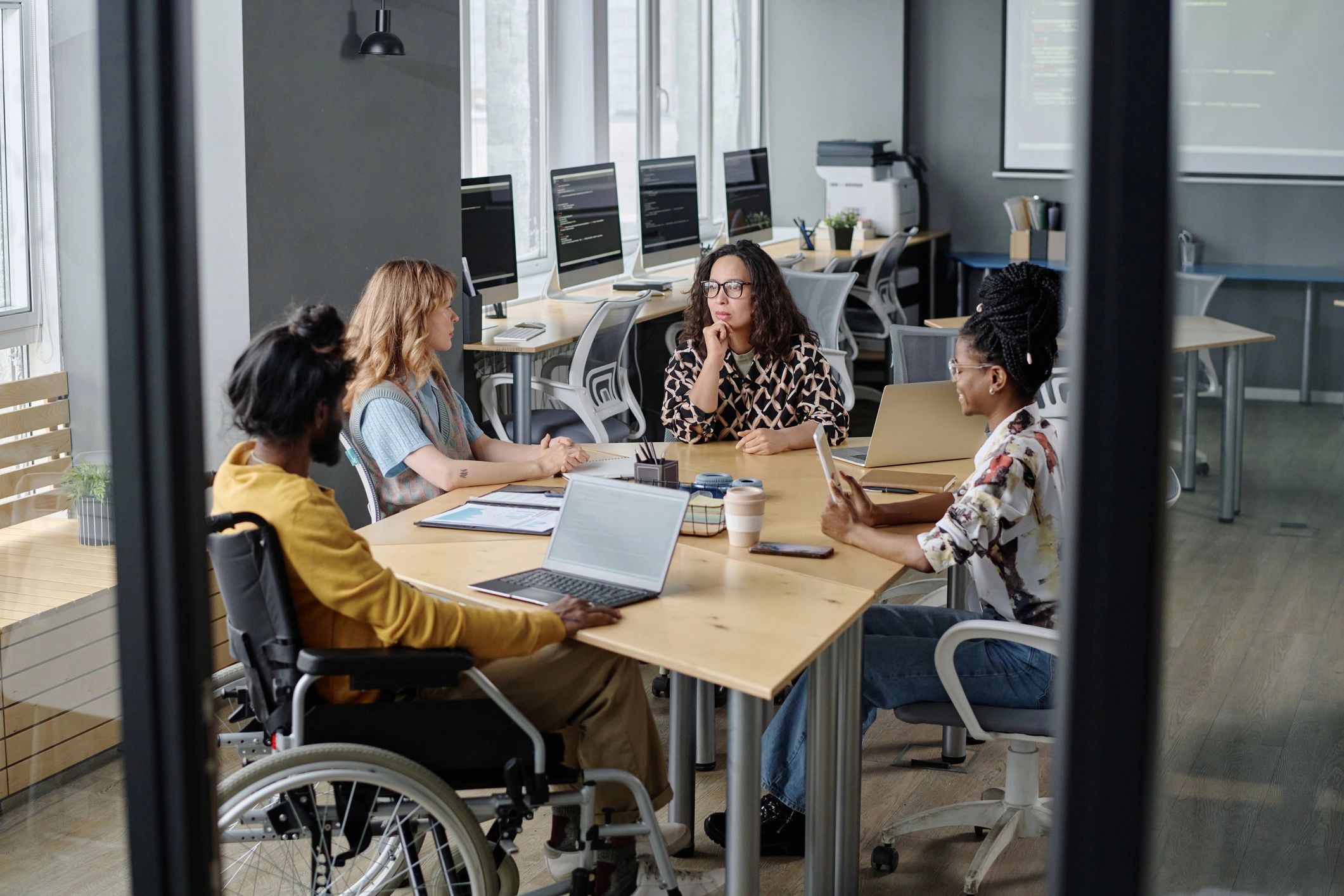 Diverse professionals collaborating at a desk in a modern office